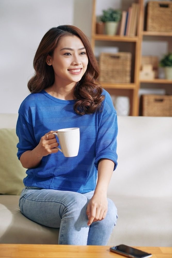 A woman enjoying a warm cup of tea at home